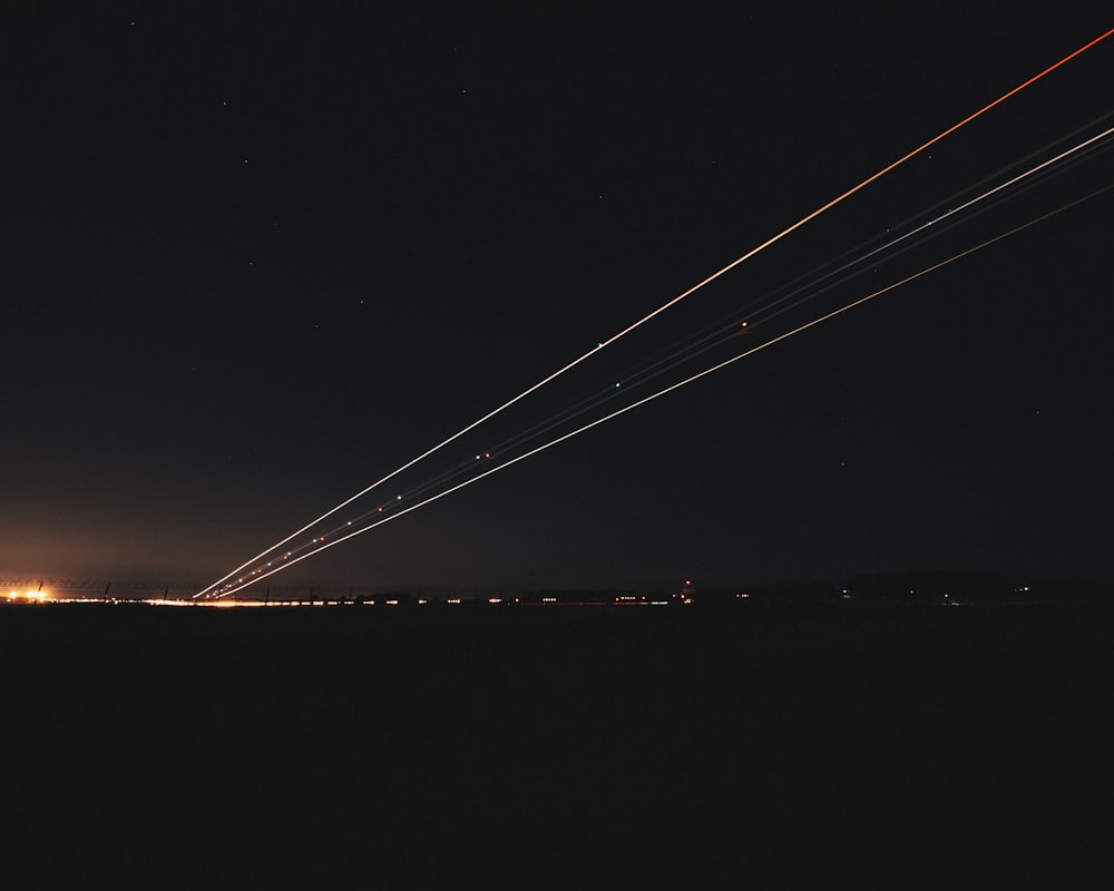 a long line of airplanes flying in the night sky