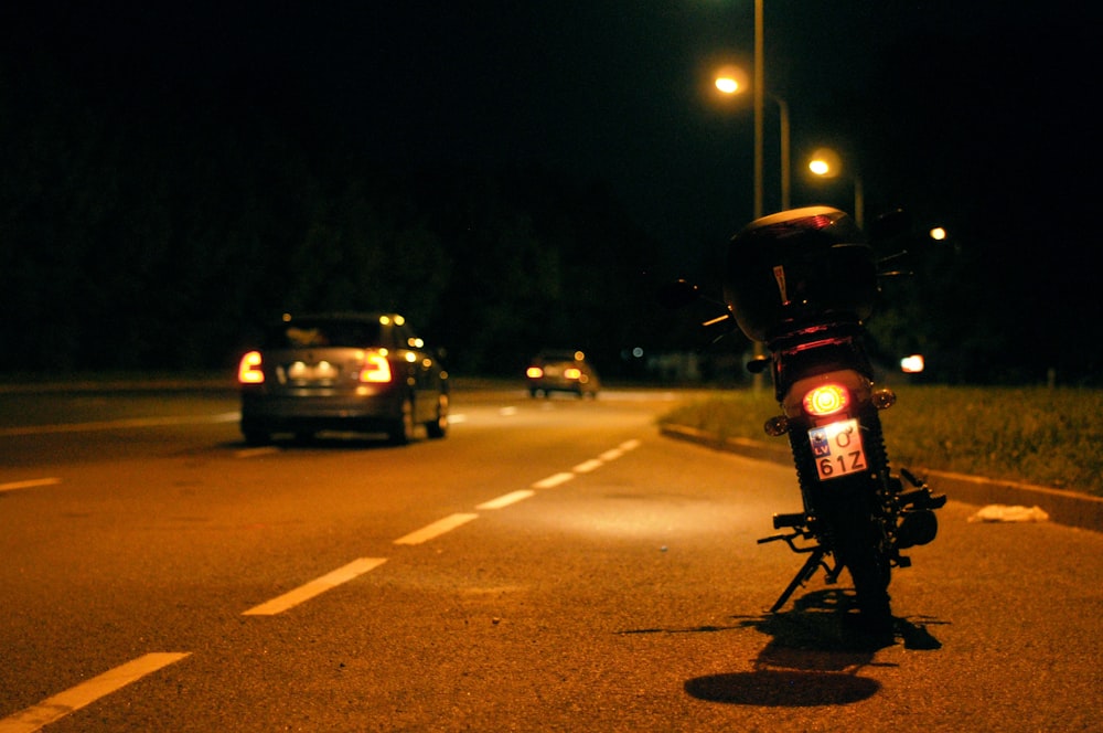 motorcycle parked besides concrete road during nighttime