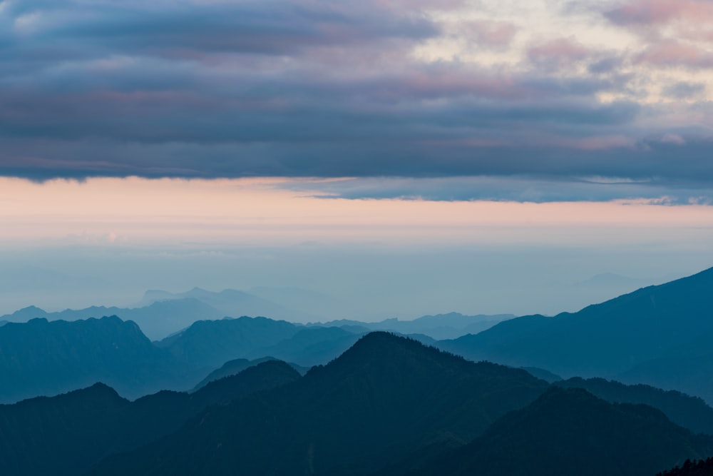 photo of mountains and clouds during dusk