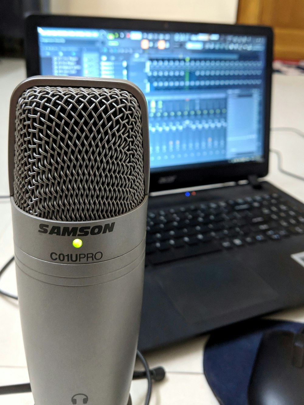 black laptop behind condenser microphone