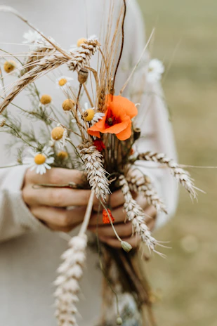 Soft-focus image of a bride’s hands holding a bouquet of wildflowers.