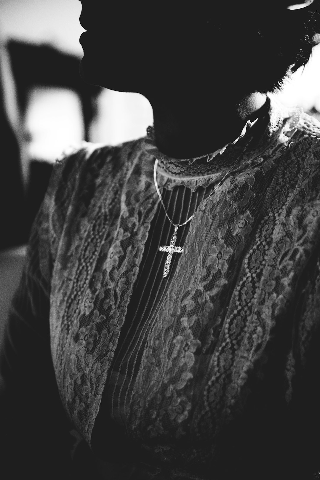 woman wearing gold-colored cross pendant necklace