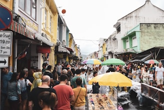 A lively group of travelers exploring a colorful street market in Malaysia.