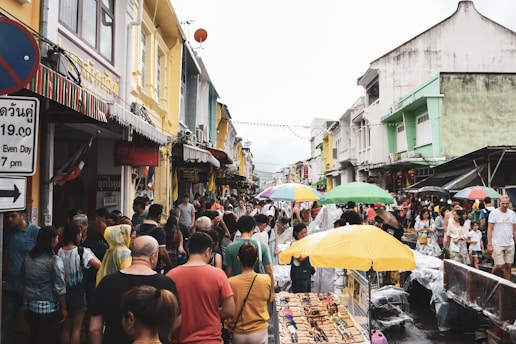 A lively group of travelers exploring a colorful street market in Malaysia.