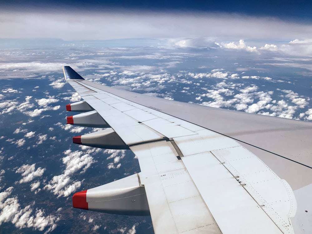 airplane wings above clouds during daytime