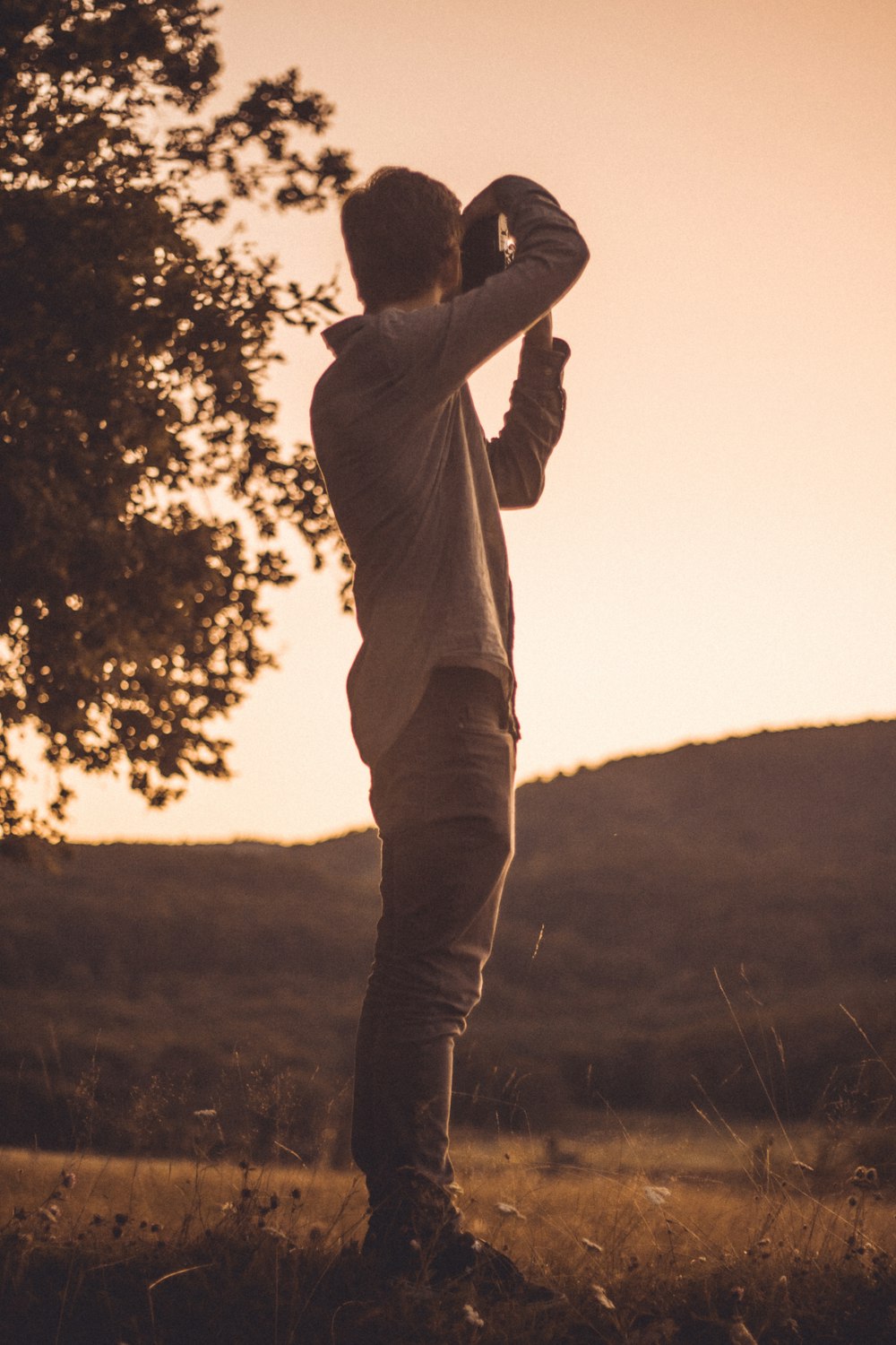 grayscale photography of man taking photo of mountain during daytime