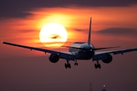 A picturesque view of an airplane landing at sunset.