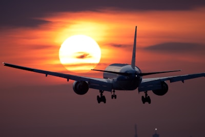 A wide-angle cinematic shot of a large cargo plane flying against a vibrant sunset sky.