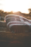 Cozy wool blankets and stone details inside a glamping pod at dusk.