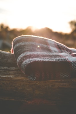 Cozy wool blankets and stone details inside a glamping pod at dusk.