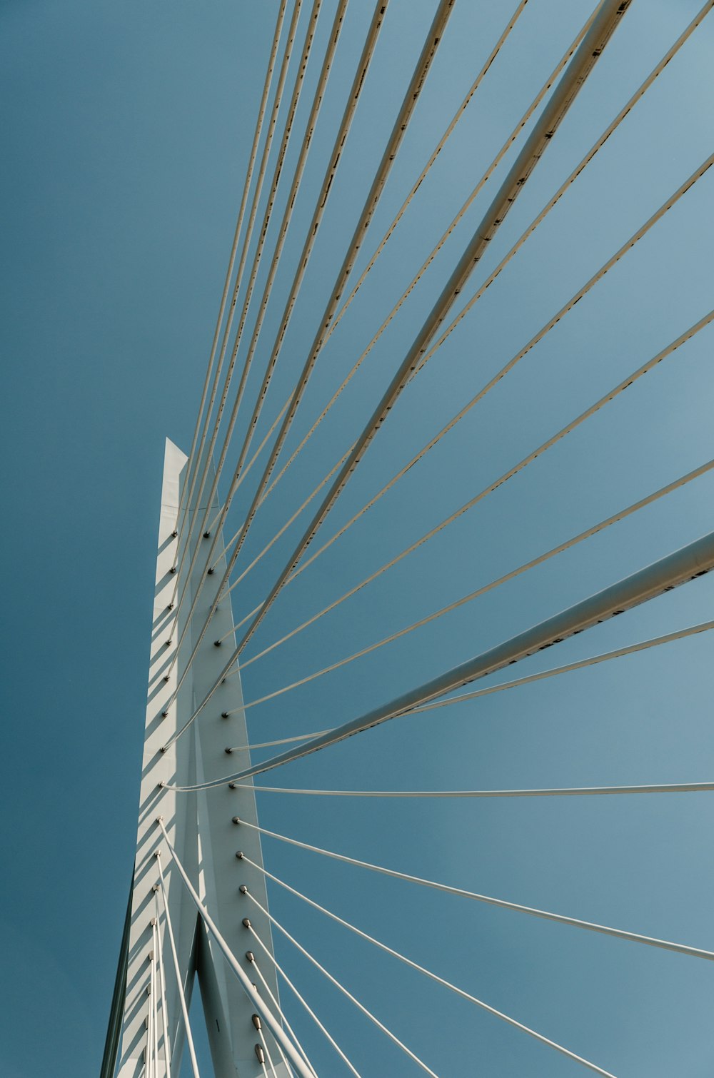 Ein Blick auf die Spitze einer weißen Brücke vor einem blauen Himmel