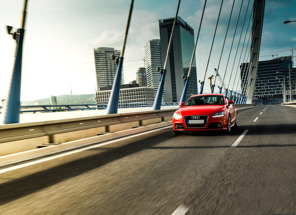 red Audi sedan running on bridge