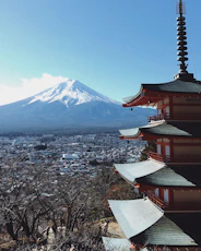 red, gray, and brown pagoda temple near mount fuji