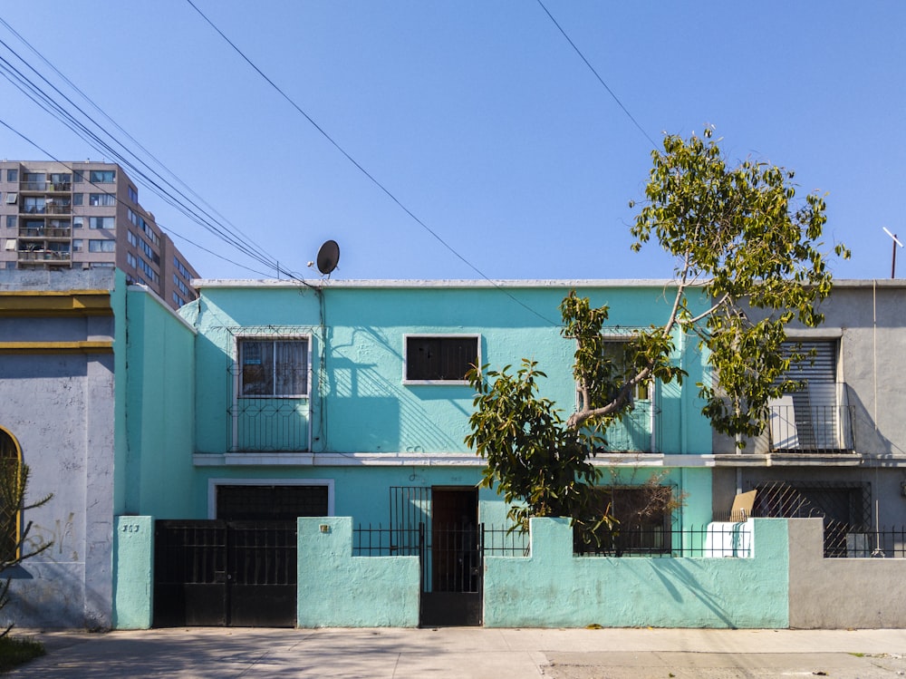 teal concrete house under blue sky