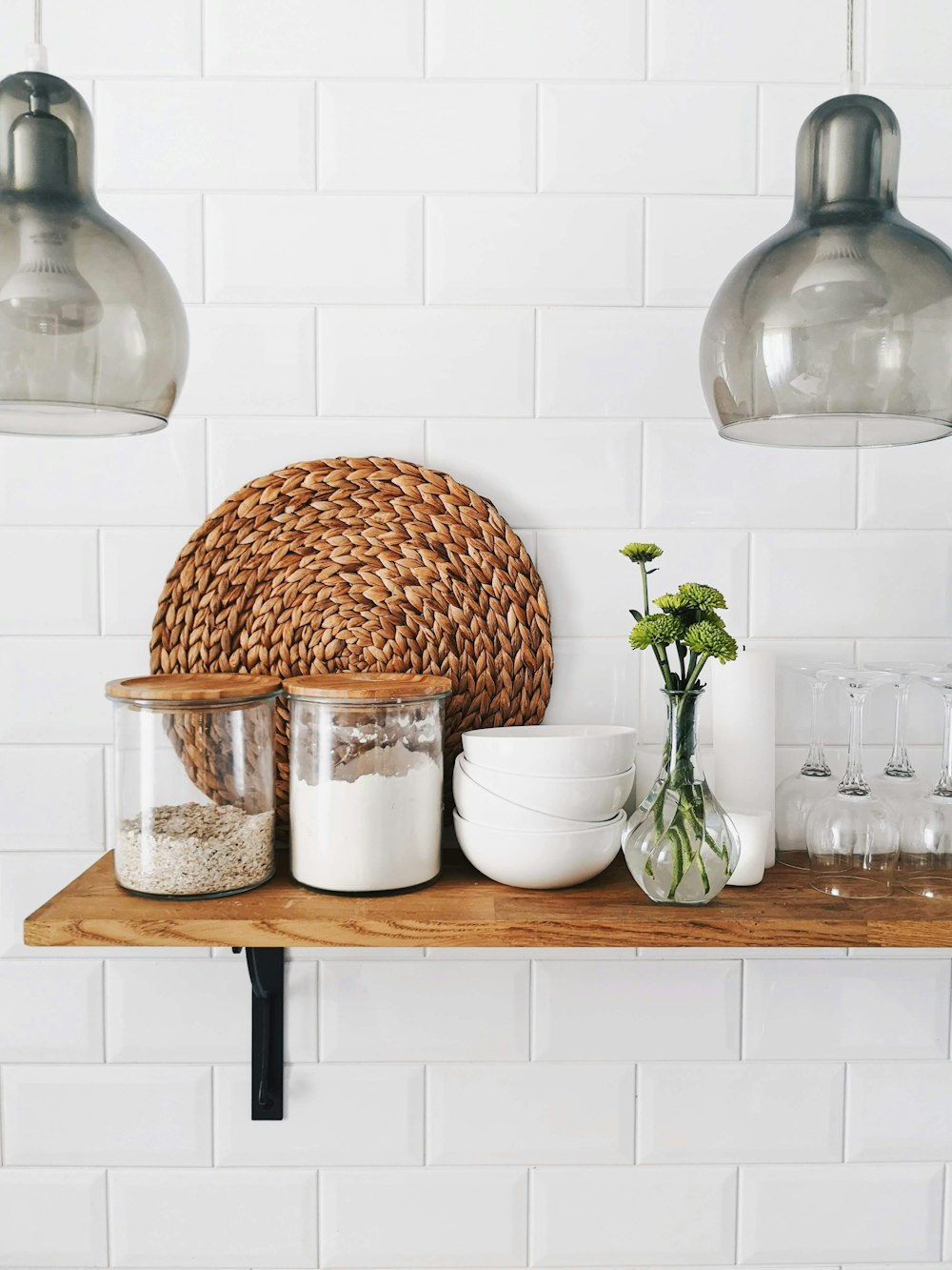 two clear glass jars on brown wooden floating shelf