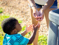 Children happily washing their hands at an outdoor water station.