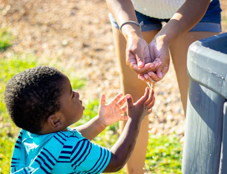 A mentor guiding a young student through a hands-on science project outdoors.