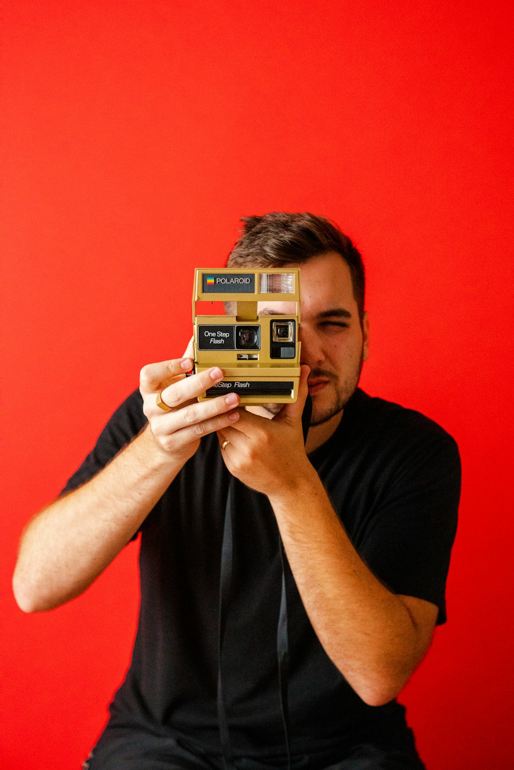 man holding vintage brown and black instant camera