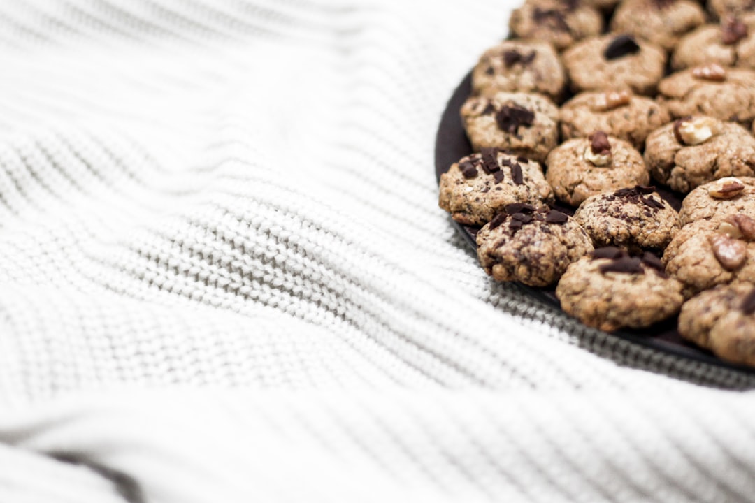 plate of baked chocolate cookies on white tablecloth