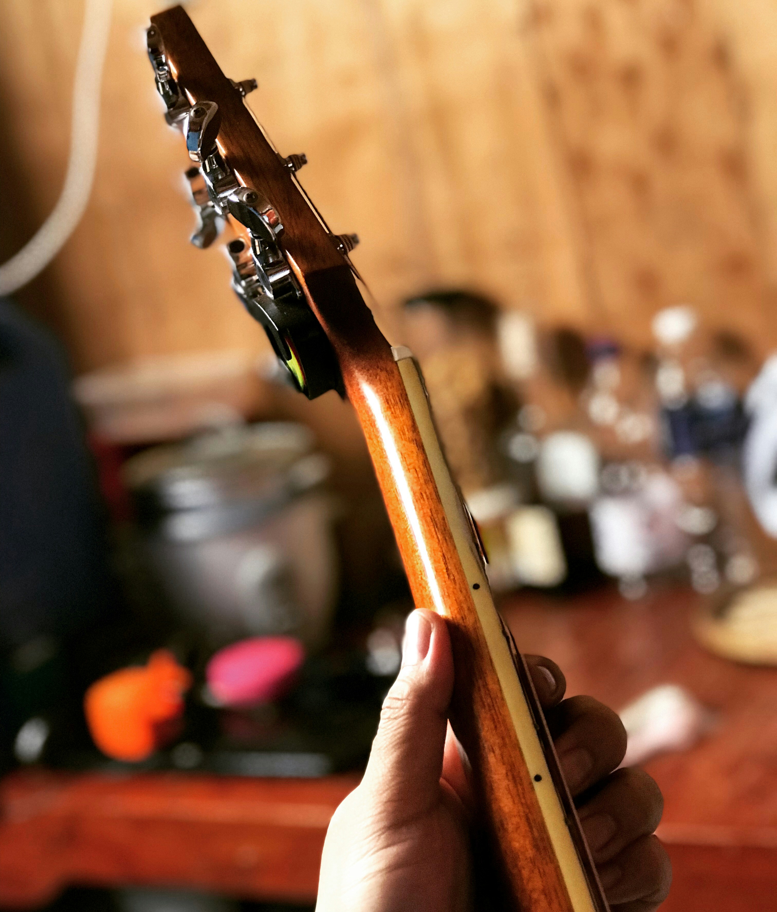person holding brown guitar