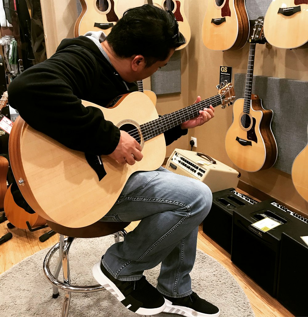 hombres tocando una guitarra en una sala de lotes de guitarra fotografía de primer plano