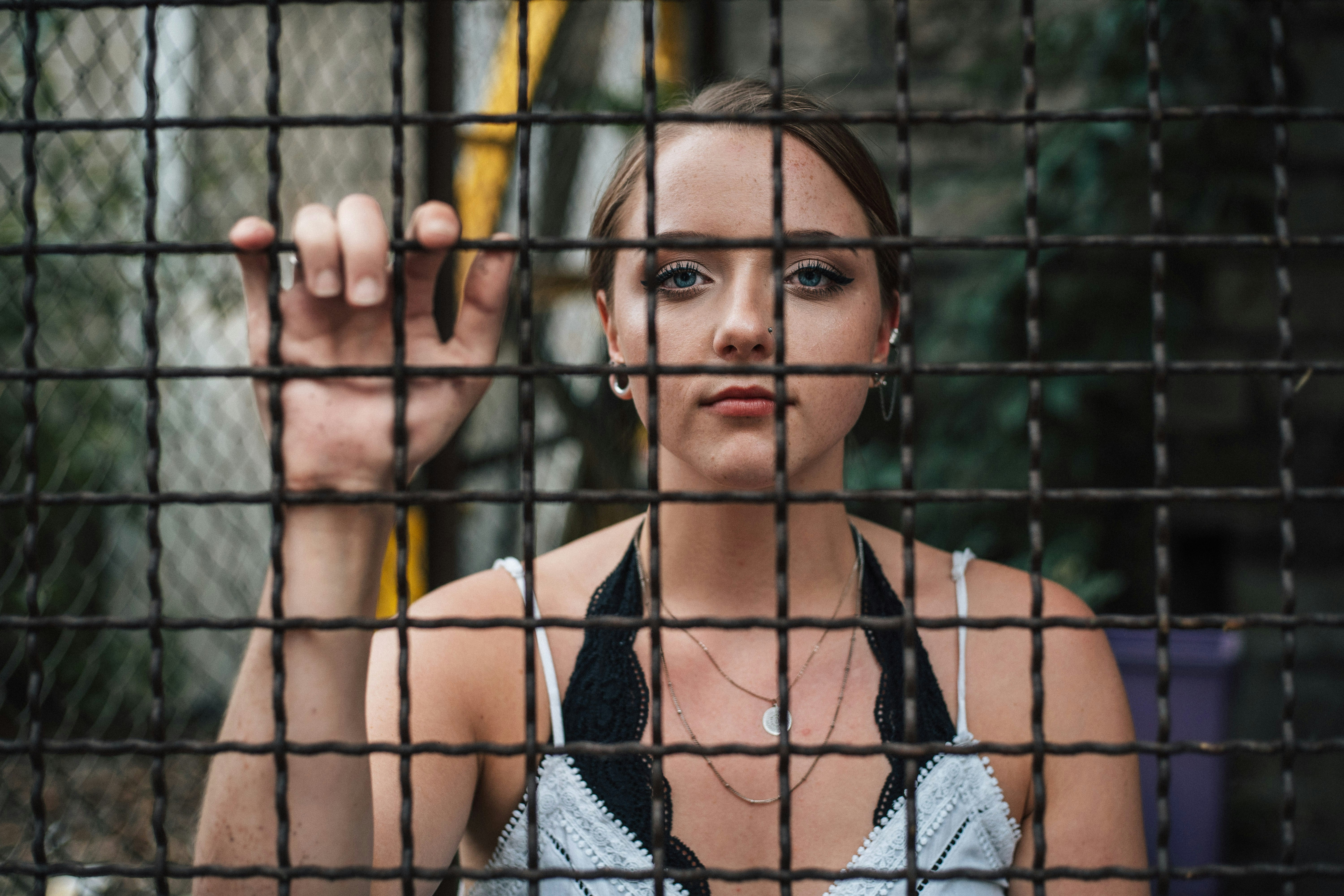woman standing behind fence