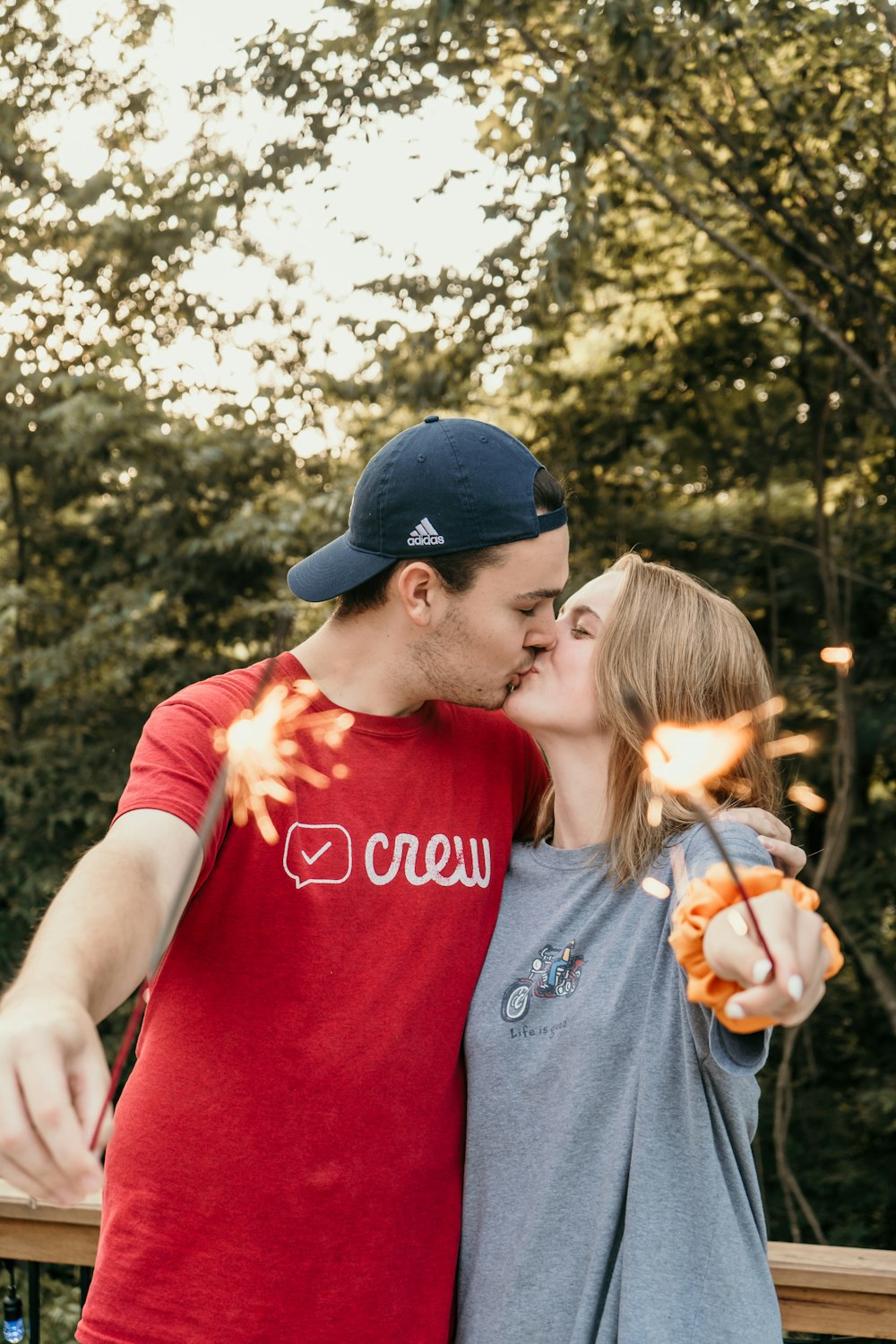 couple kissing while holding lighted sparklers