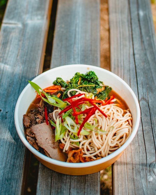 Noodles with sliced red bell pepper, carrots, and meat