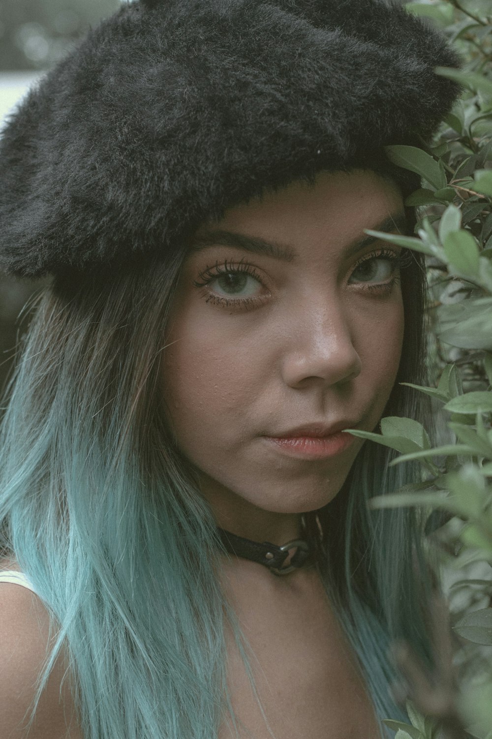 a woman with blue hair wearing a black hat