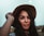 a woman in a hat poses for a picture