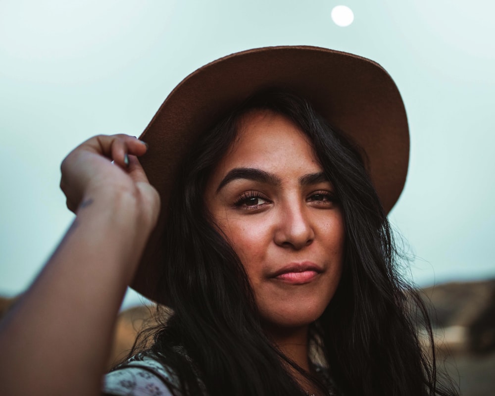 a woman in a hat poses for a picture