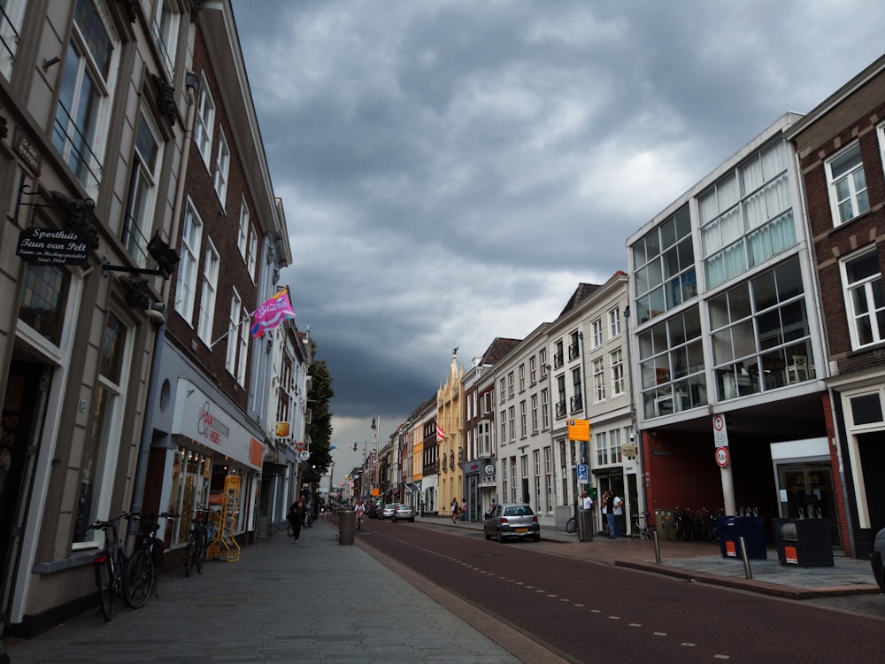 a city street lined with tall buildings under a cloudy sky