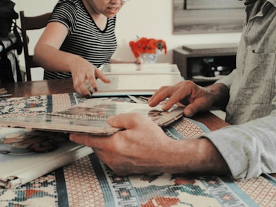 A family gathered around a coffee table, reading a memory book together.