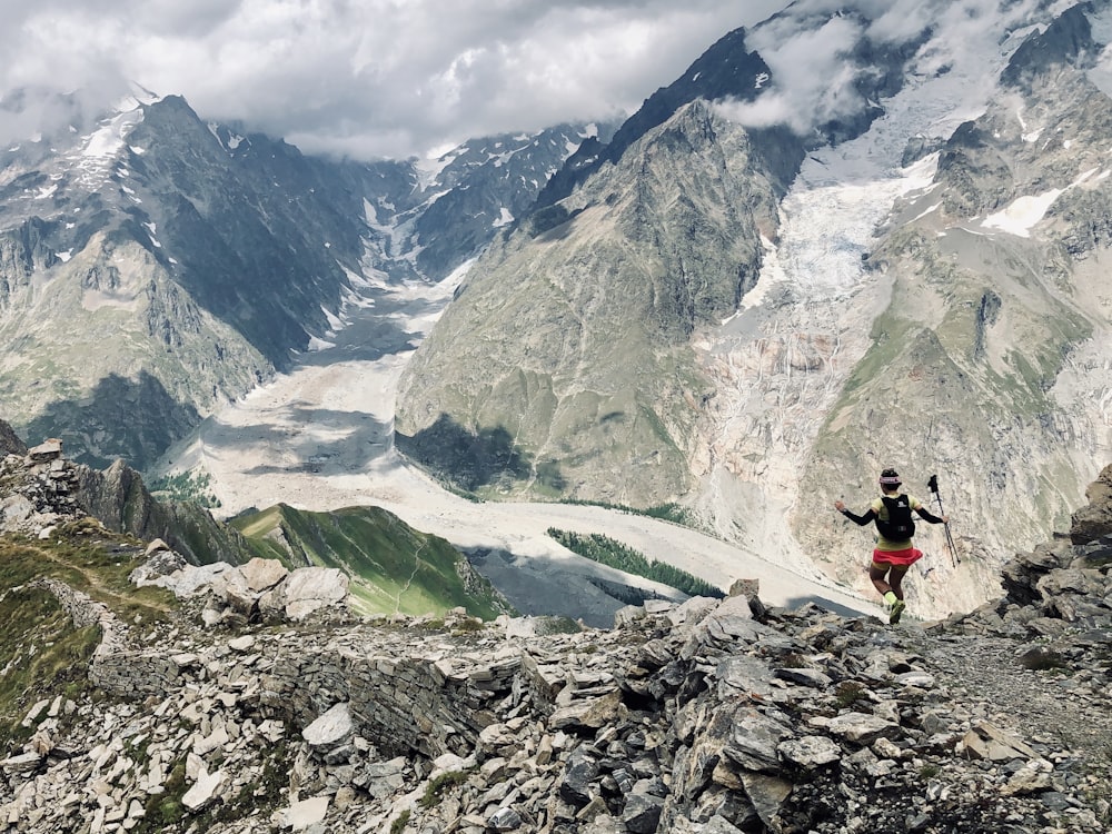 a man hiking up a mountain with a view of a valley below