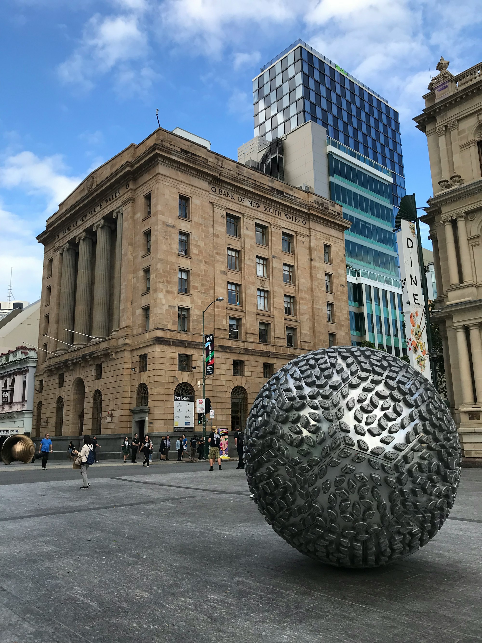 silver globe statue outside a concrete building