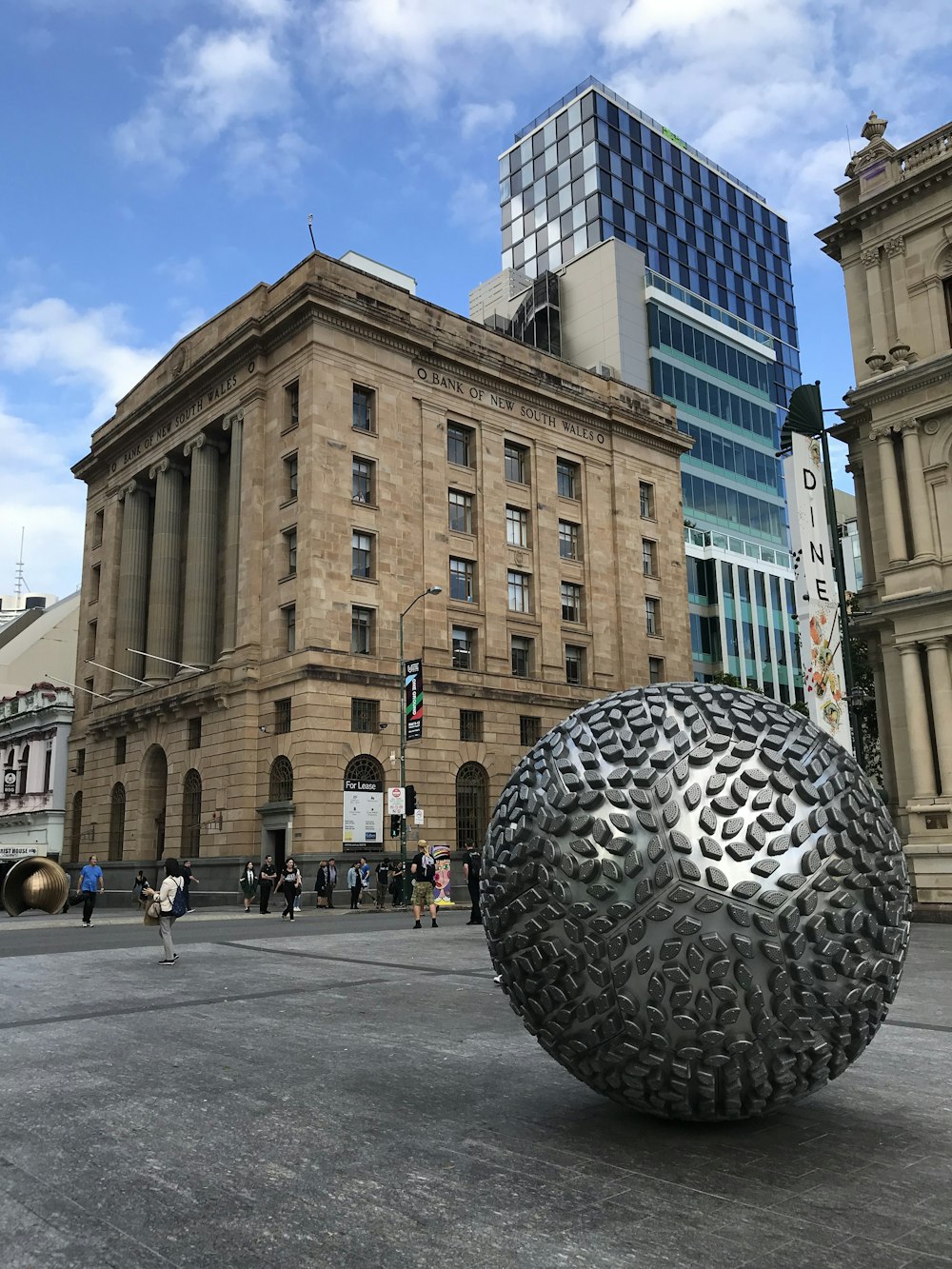 silver globe statue outside a concrete building