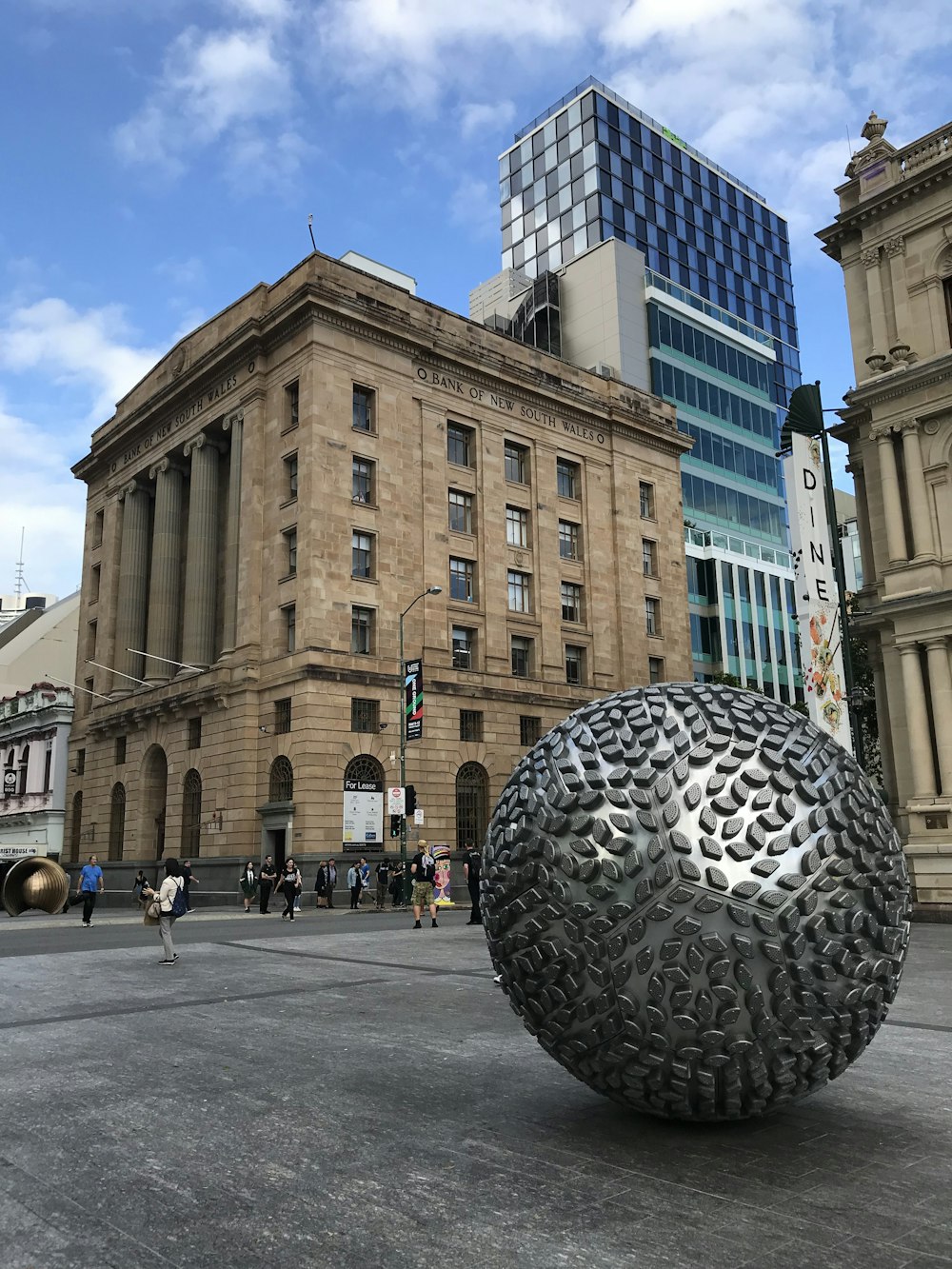 Silberkugel-Statue vor einem Betongebäude