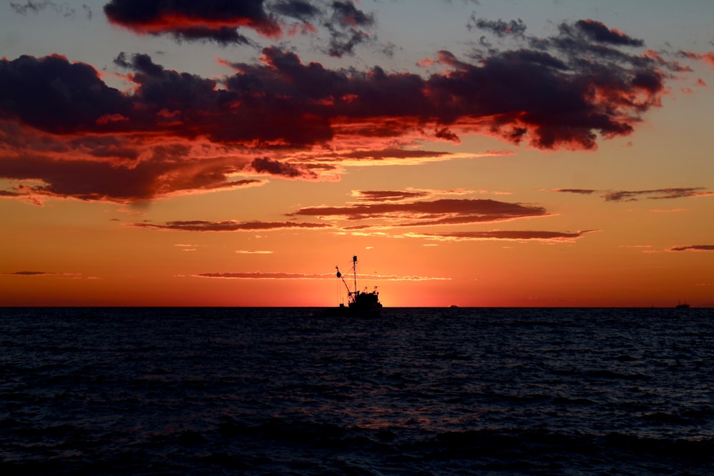 a boat in the ocean during a sunset