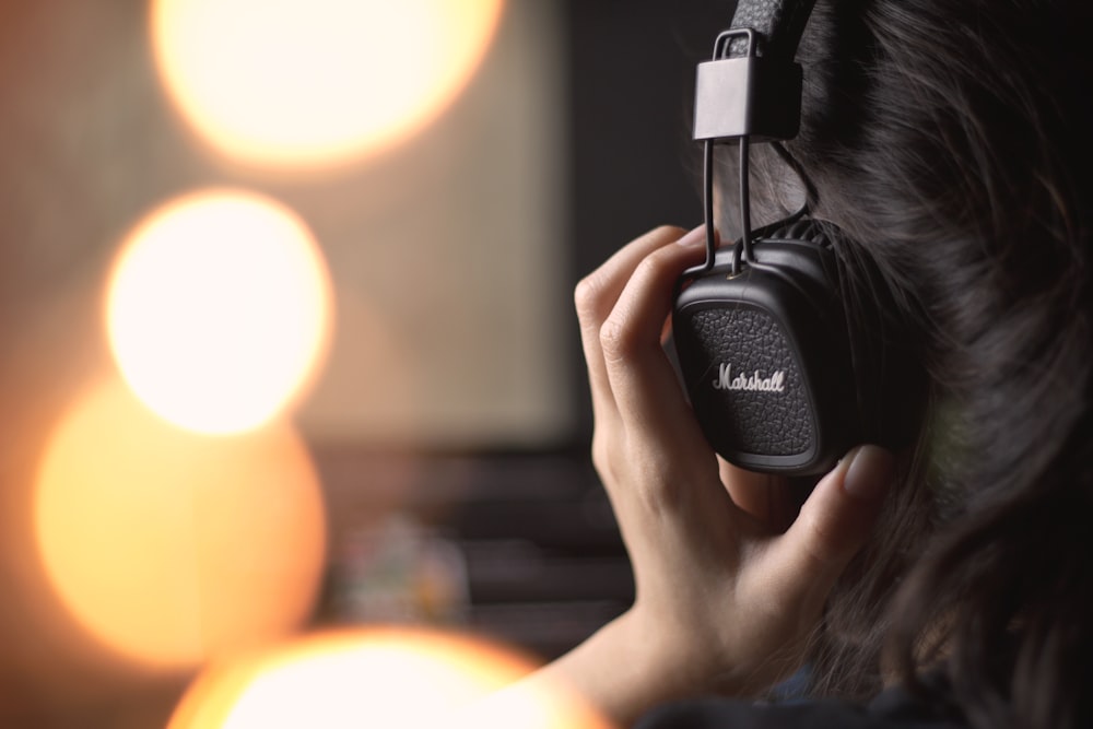 selective focus photography of person wearing black headphone