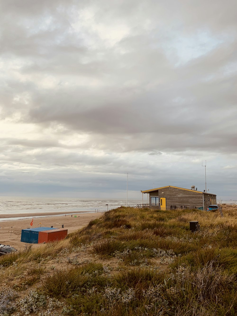 a house on a beach with a boat in the water