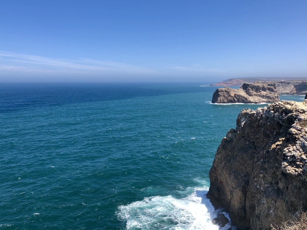 aerial photography of mountain cliff by the sea during daytime