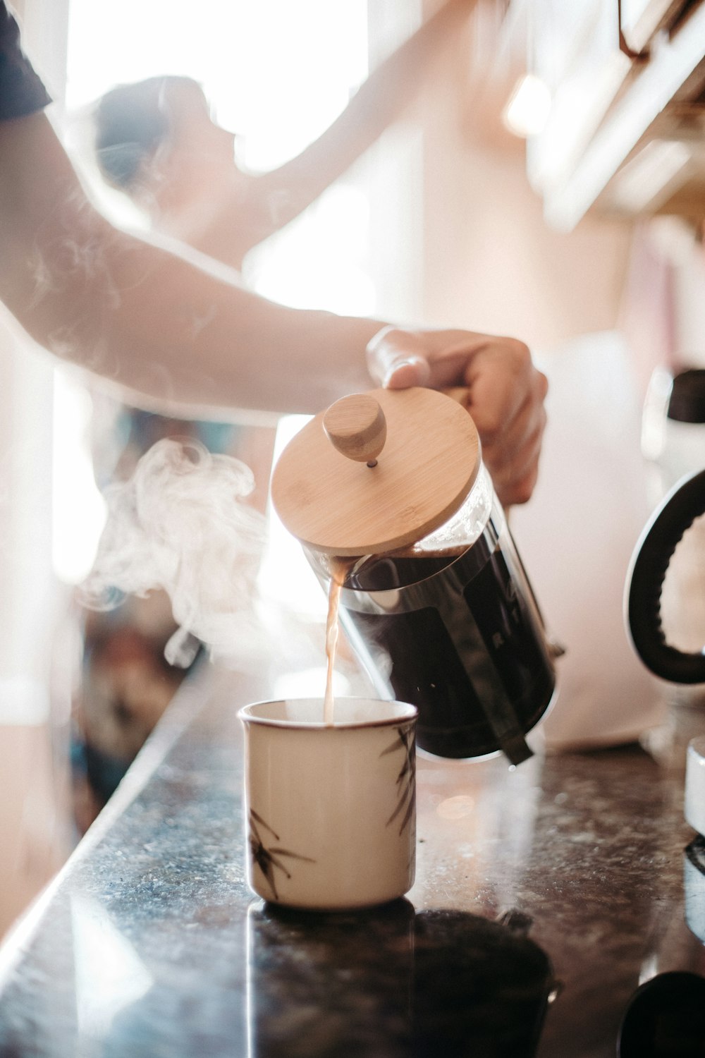 Photographie en accéléré de la personne versant du café sur la tasse