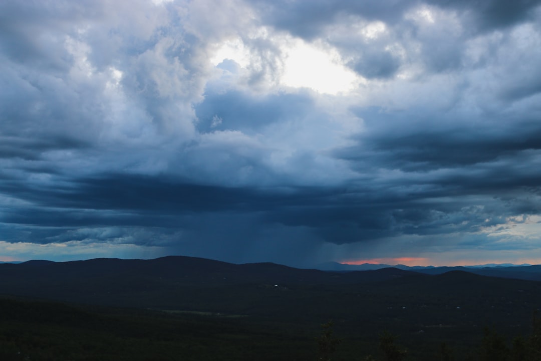 silhouette of mountain under blue and white skies, A rain storm approaches in the White Mountains. Follow on Instagram @