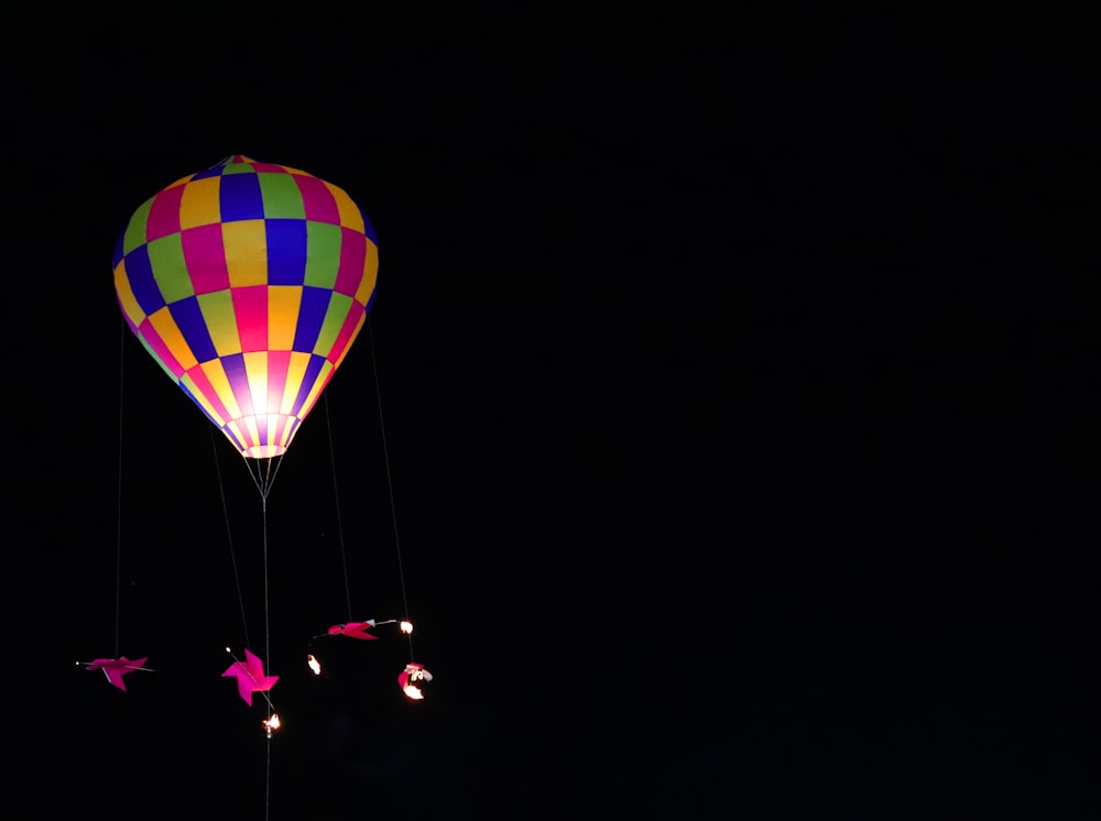 a colorful hot air balloon flying in the dark