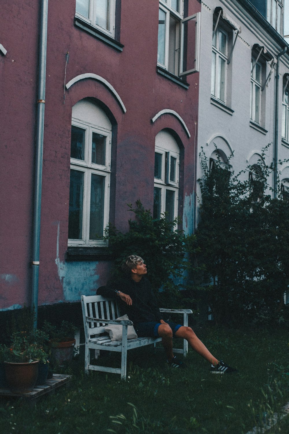 man sitting on white wooden bench