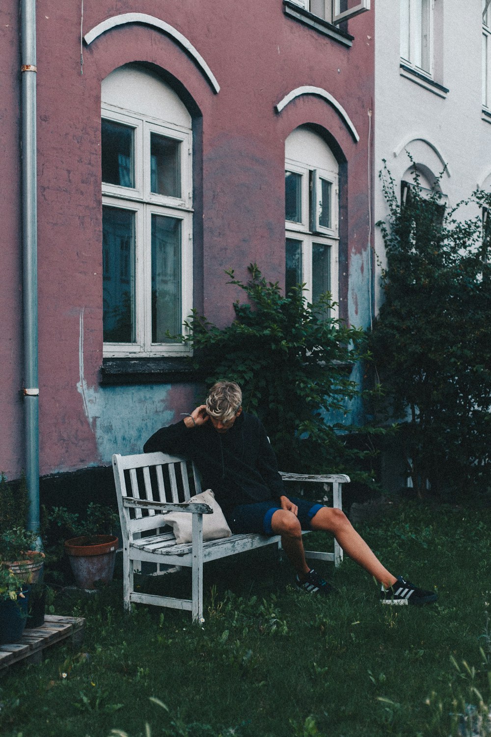 man wearing black sweater sitting on wooden bench