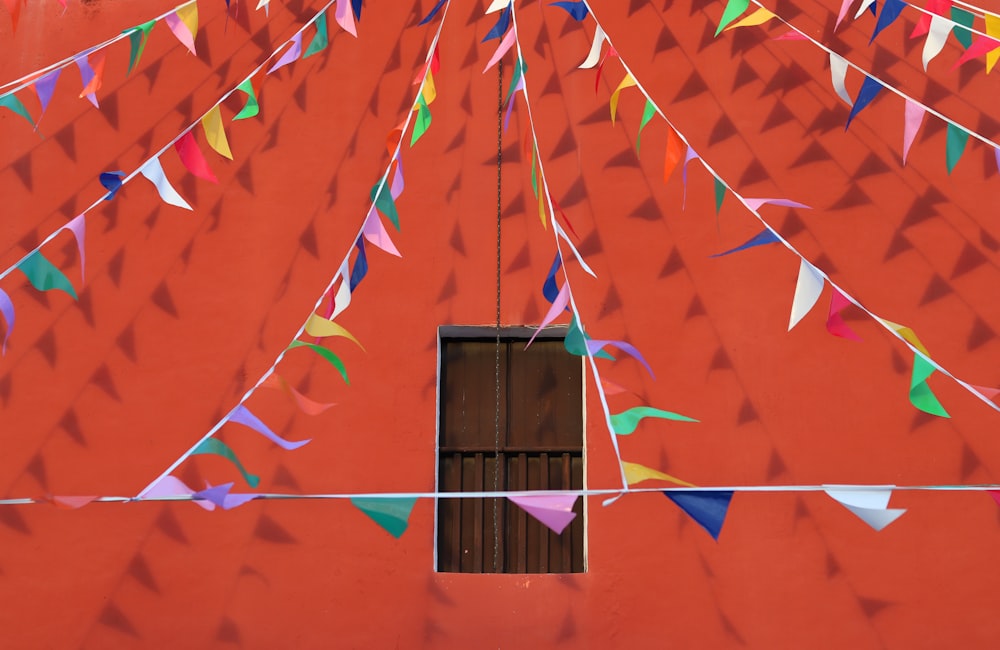 a red building with colorful flags hanging from it's side