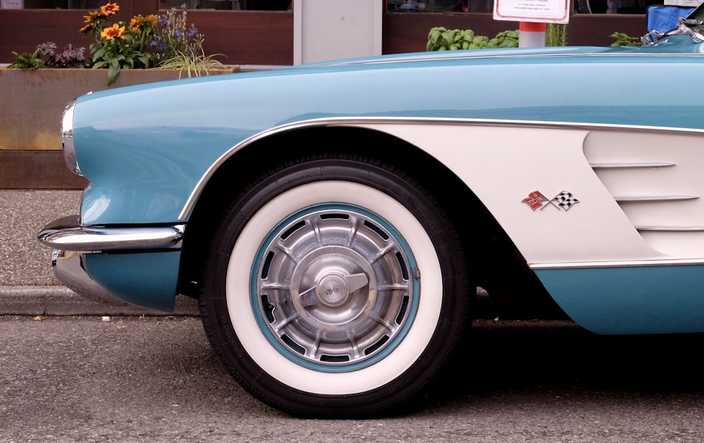 a blue and white car parked on the side of the road