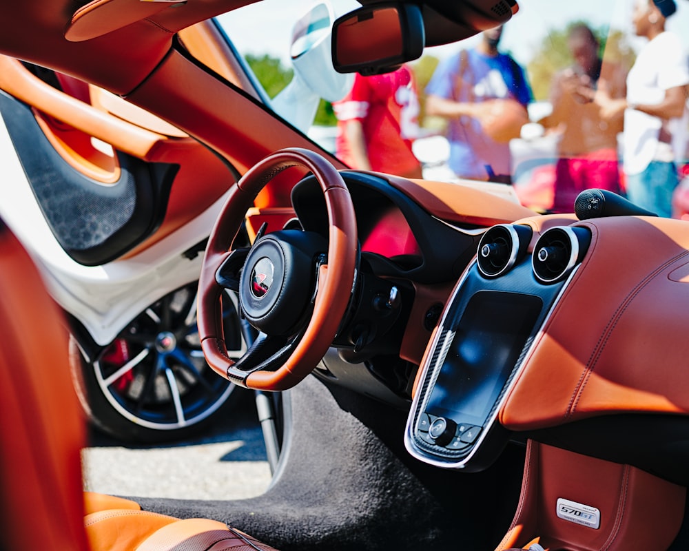 orange sport car near people