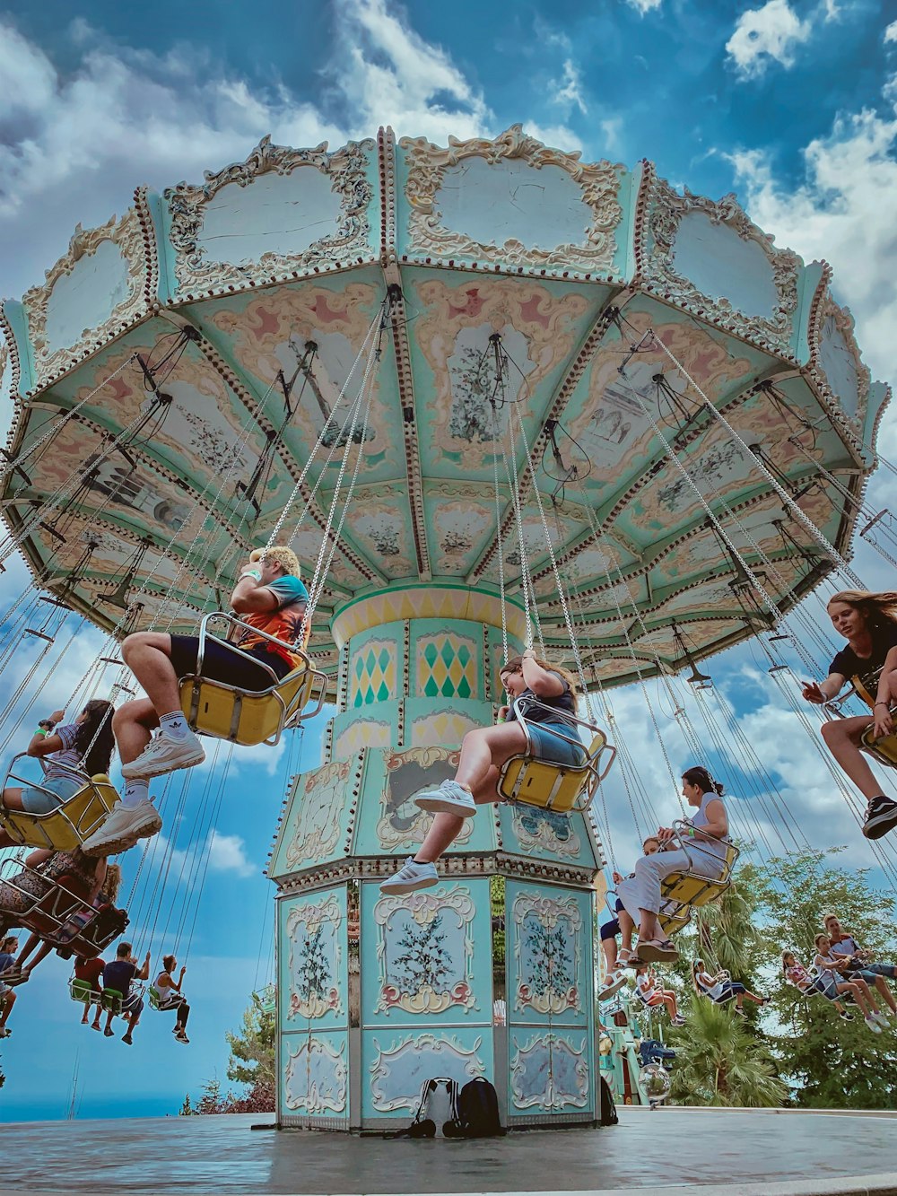 people riding on merry-go-round during daytime
